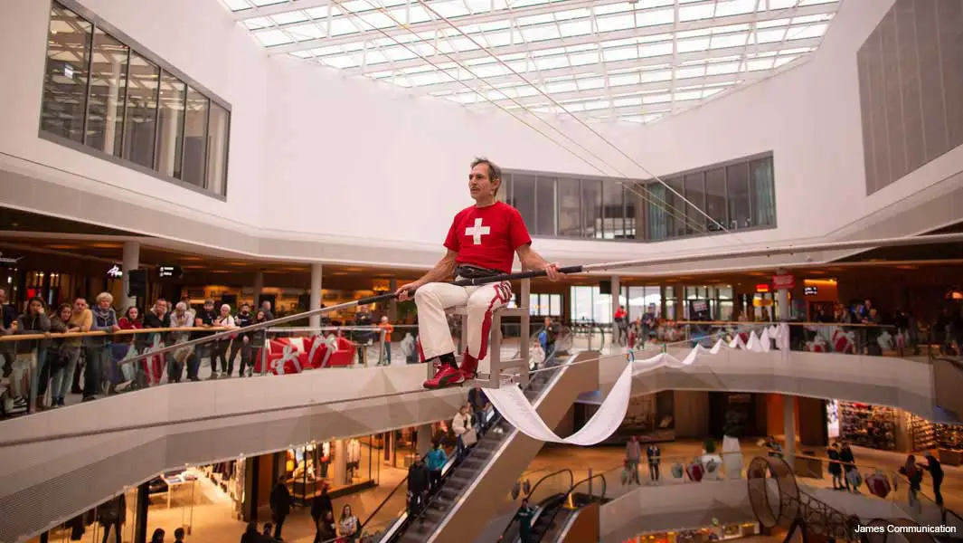 Stuntman balanciert acht Stunden auf einem Stuhl auf einem Hochseil in einem Kaufhaus